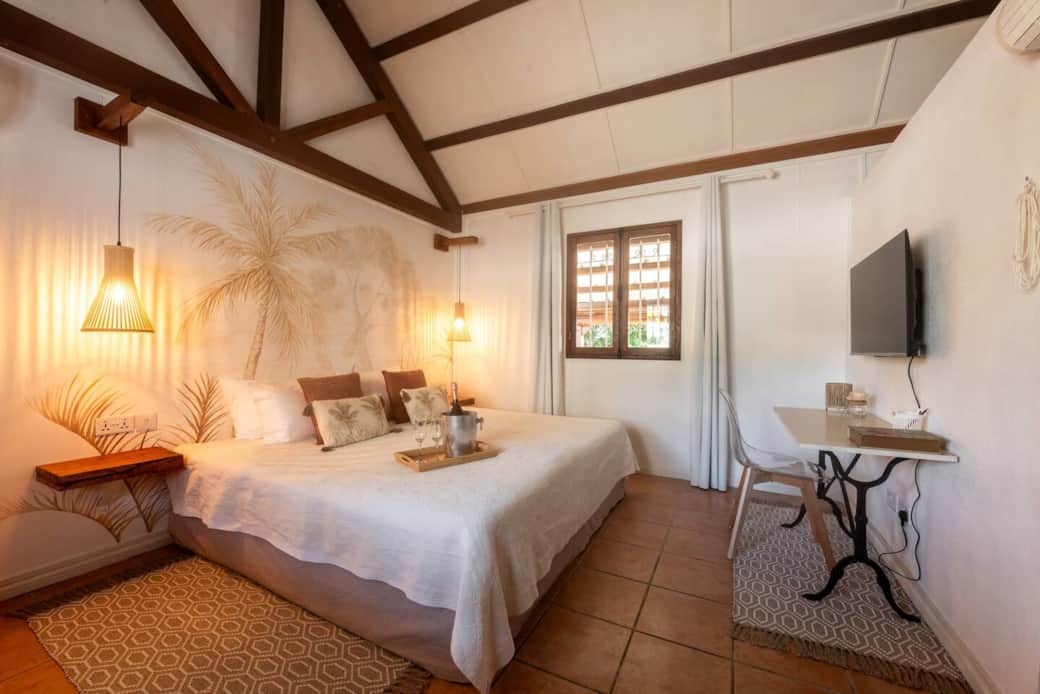 Bright and cozy with a king-size bed, tropical decor, and a small desk area