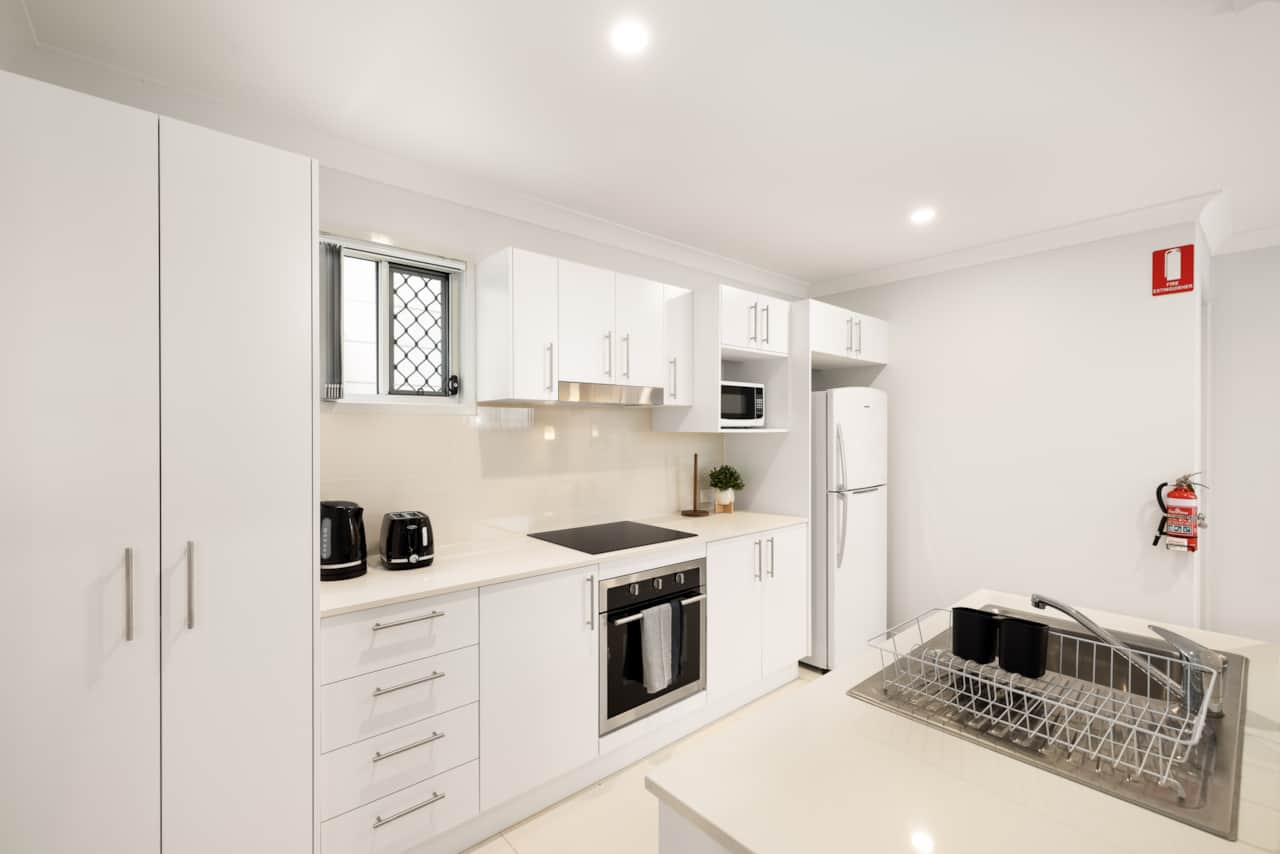 Kitchen: Sleek kitchen with ample storage, modern appliances 