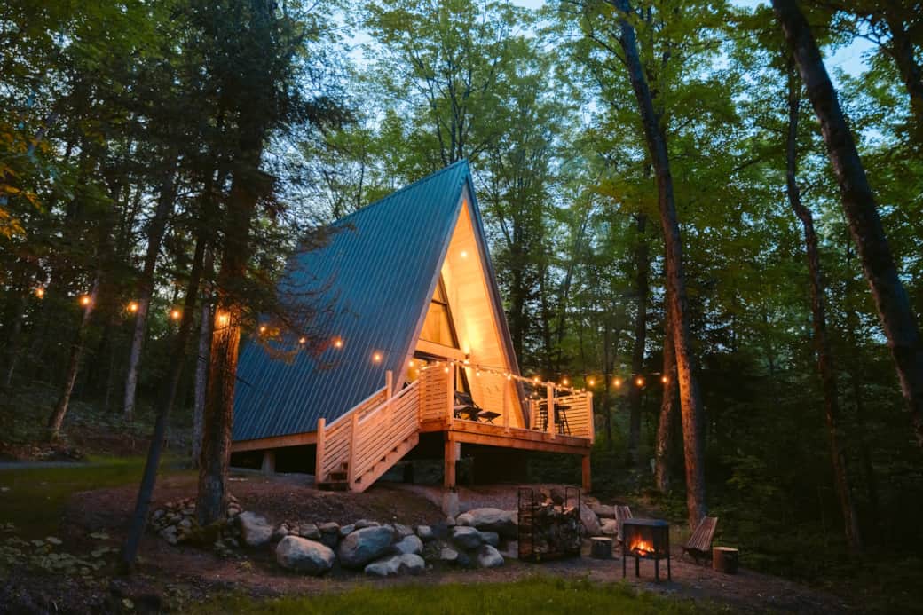 The cabin glowing at dusk, in the heart of the forest. Photo credit: @rollingvan