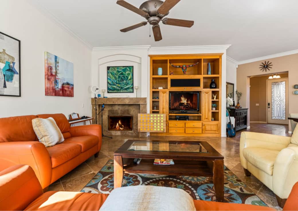 Relax in this open-concept living room featuring cozy leather seating, a custom wood entertainment c Relax in this open-concept living room featuring cozy leather seating, a custom wood entertainment c