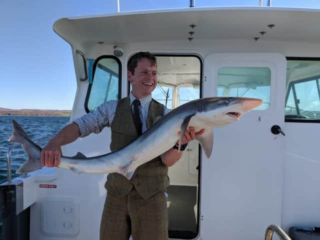 Angler holding a fish aboard a Hooked on Mull charter boat