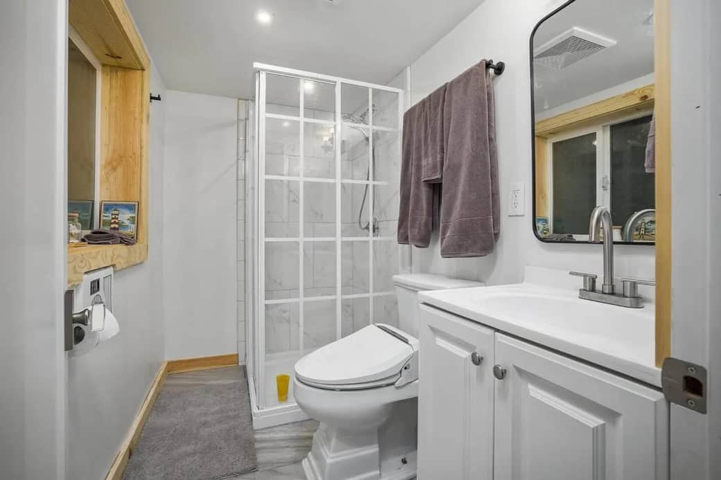 Bright, modern bathroom with walk-in shower, spacious vanity, and fresh linens.