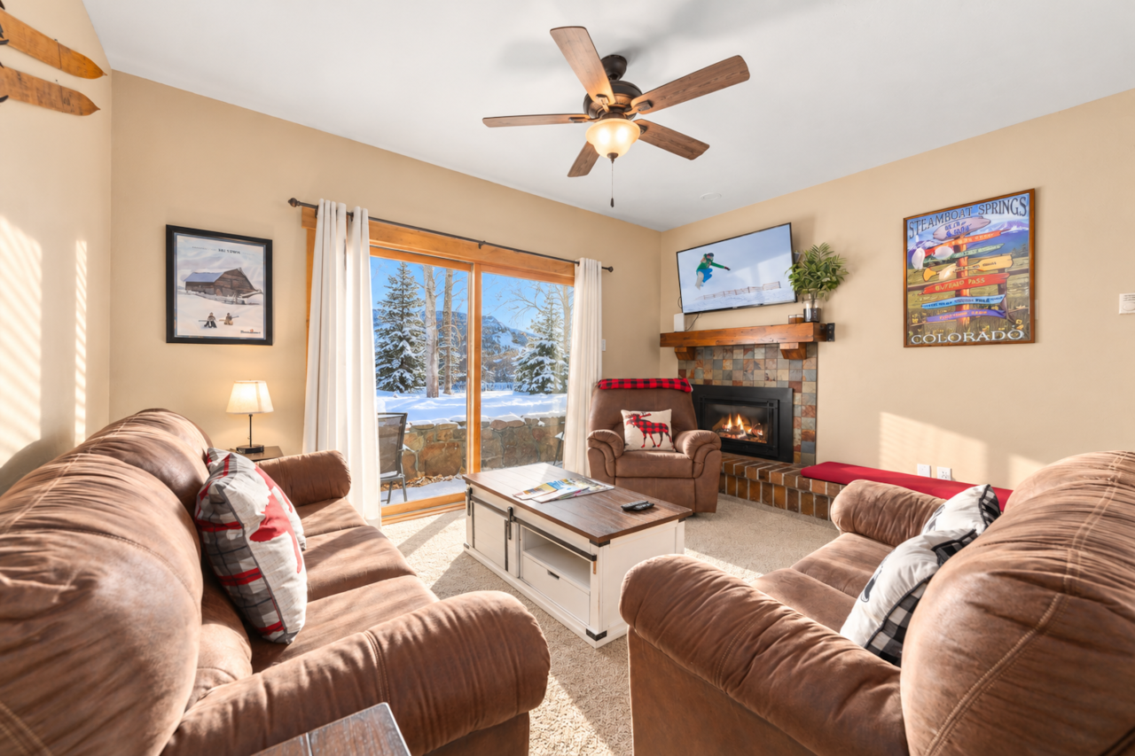Cozy Steamboat Springs living room with comfortable seating, fireplace, and snowy views.