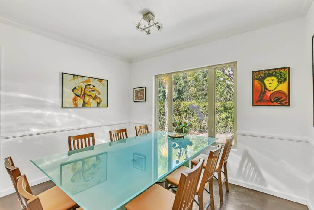 Dining area features a large, glass-top table with comfortable seating for 8 w/ access to the patio