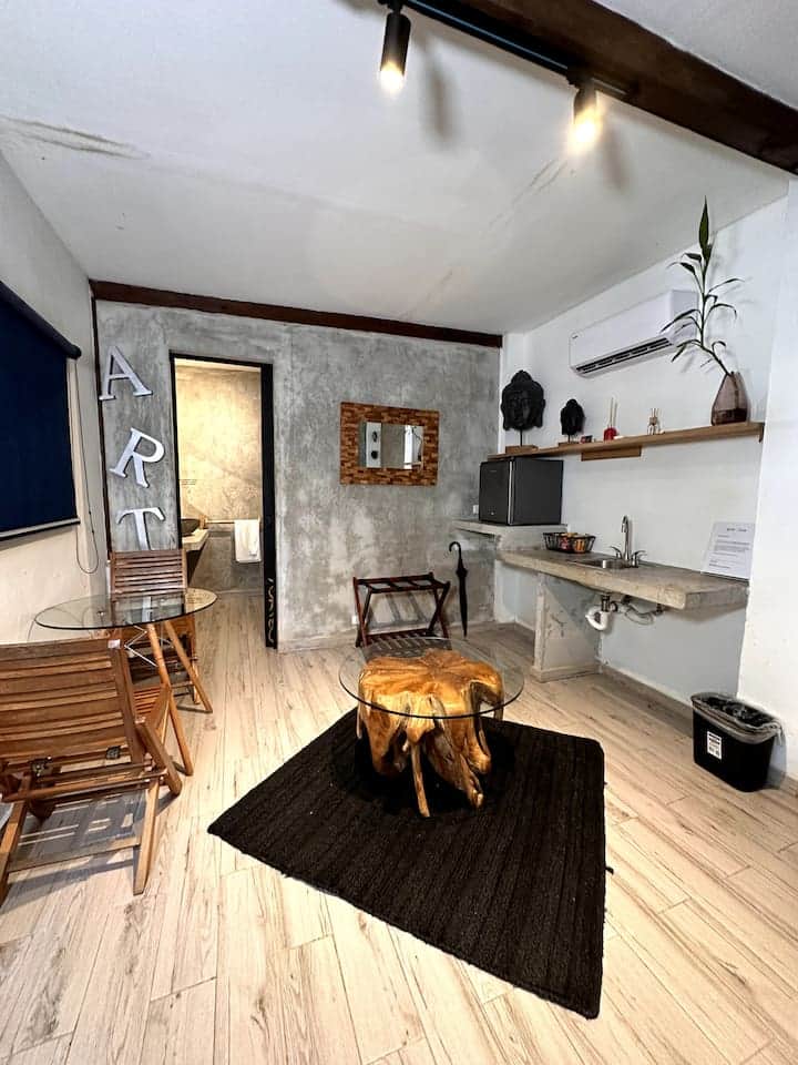Root-wood coffee table with a glass top and bistro seating in a suite at Saboga Lodge