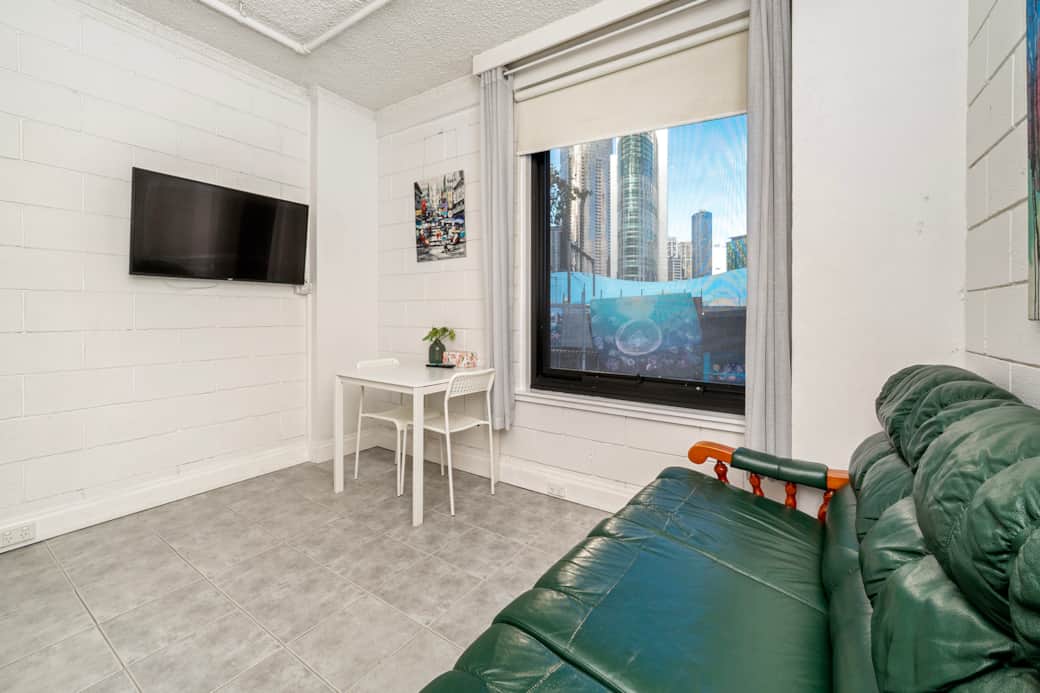 Comfortable living area with couch and large screen TV Flinders Street studio Melbourne ShelleyStayz
