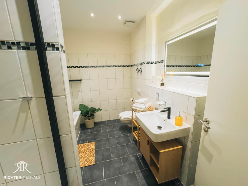 Freundliches Badezimmer mit Dusche, Badewanne & modernen Waschbecken Freundliches Badezimmer mit Dusche, Badewanne & modernen Waschbecken