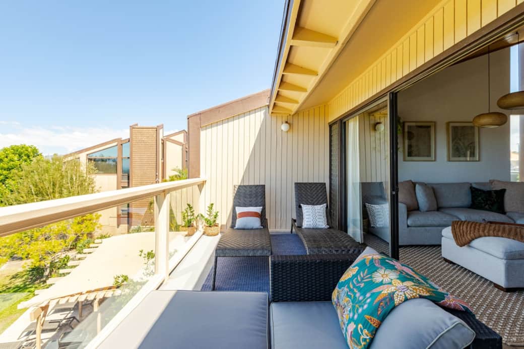 Private outdoor lanai with two comfortable lounge chairs, perfect for relaxing and enjoying the fresh air.