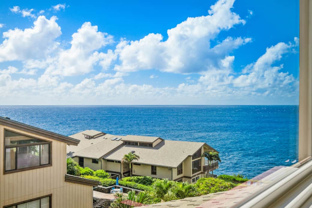 Partial ocean view from the loft overlooking lush tropical grounds and neighboring buildings