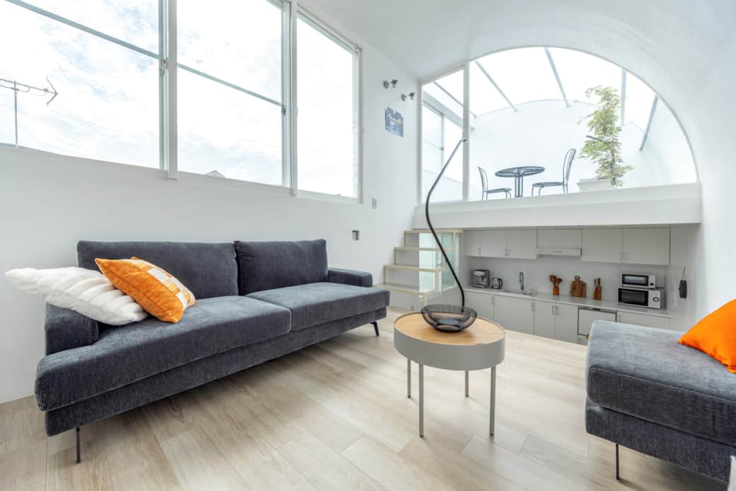 The sunlit living area of Ushida House, where curved architectural lines and minimalist textures. The sunlit living area of Ushida House, where curved architectural lines and minimalist textures.