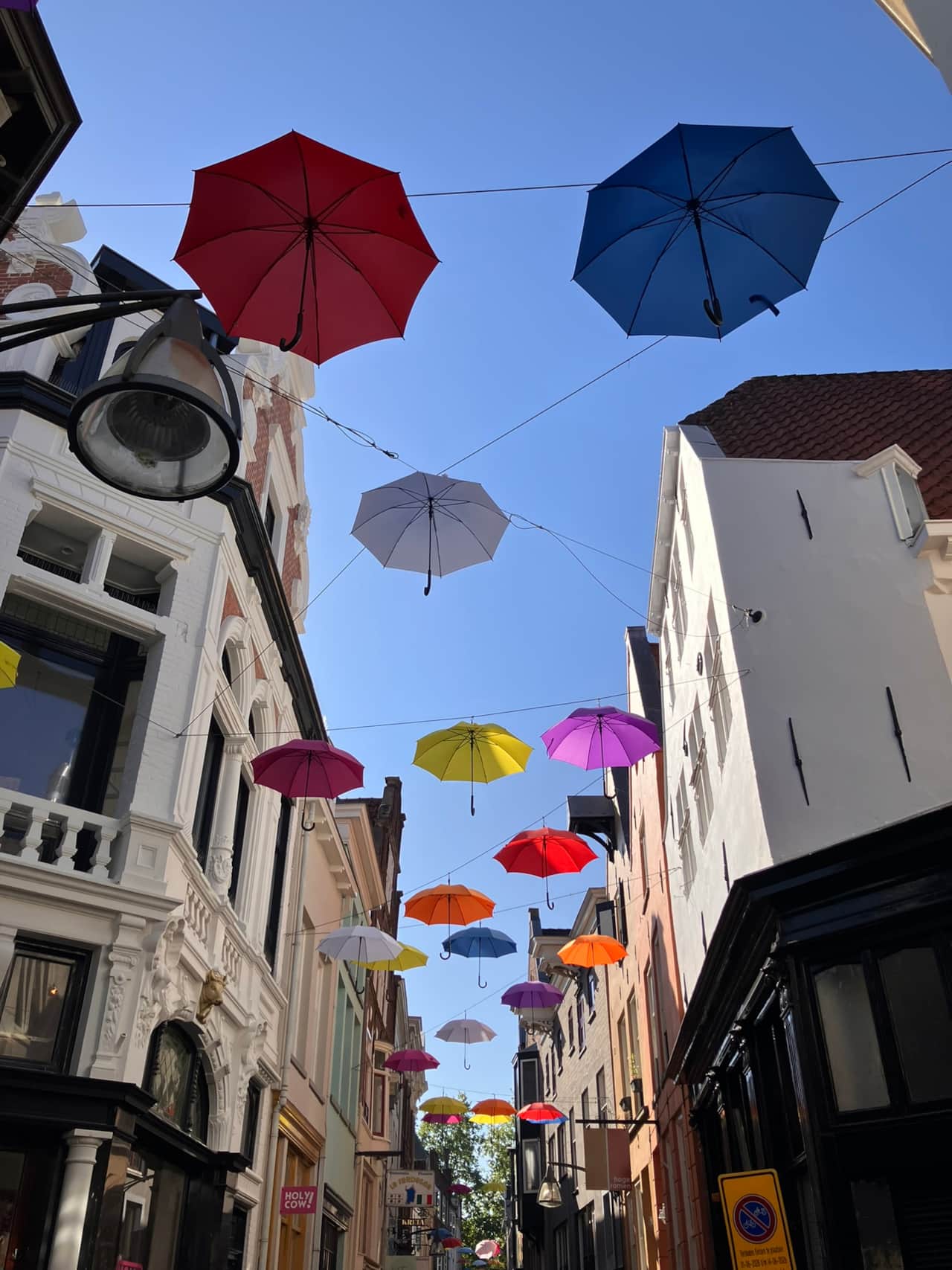 Historic pedestrian street near Gilded Ox Suites in Deventer, decorated with hanging umbrellas