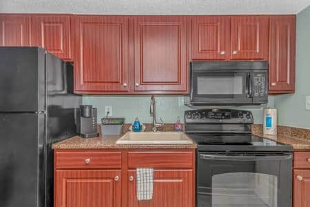 Well-equipped kitchenette featuring full-size appliances, Keurig, stove, and plenty of storage.