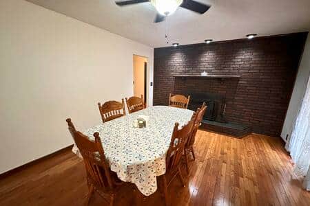 Dining Room table with back door to deck and barbeque grill.