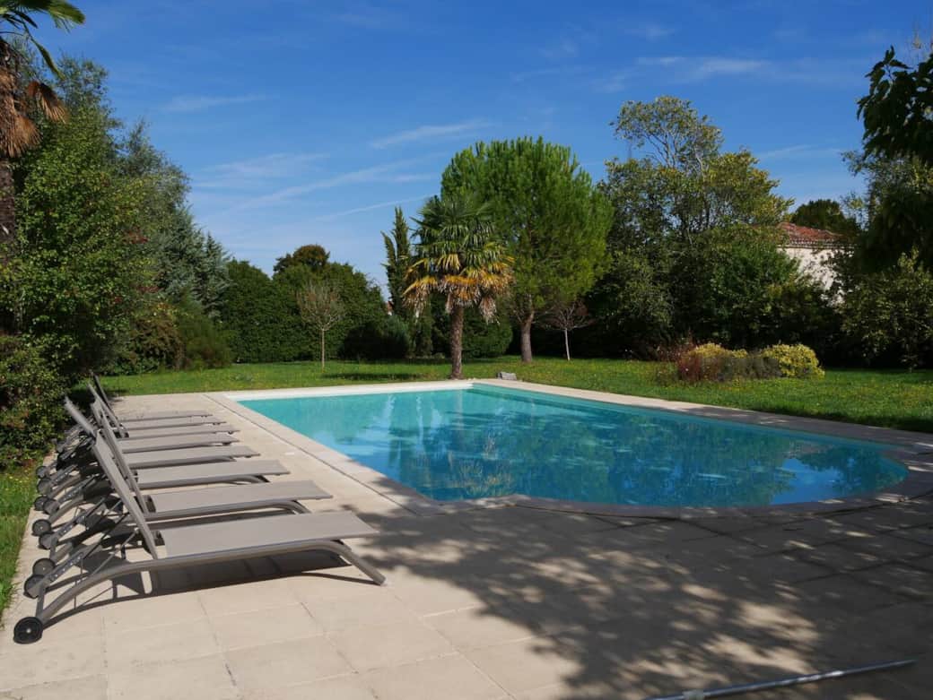 Vue de la piscine avec transats