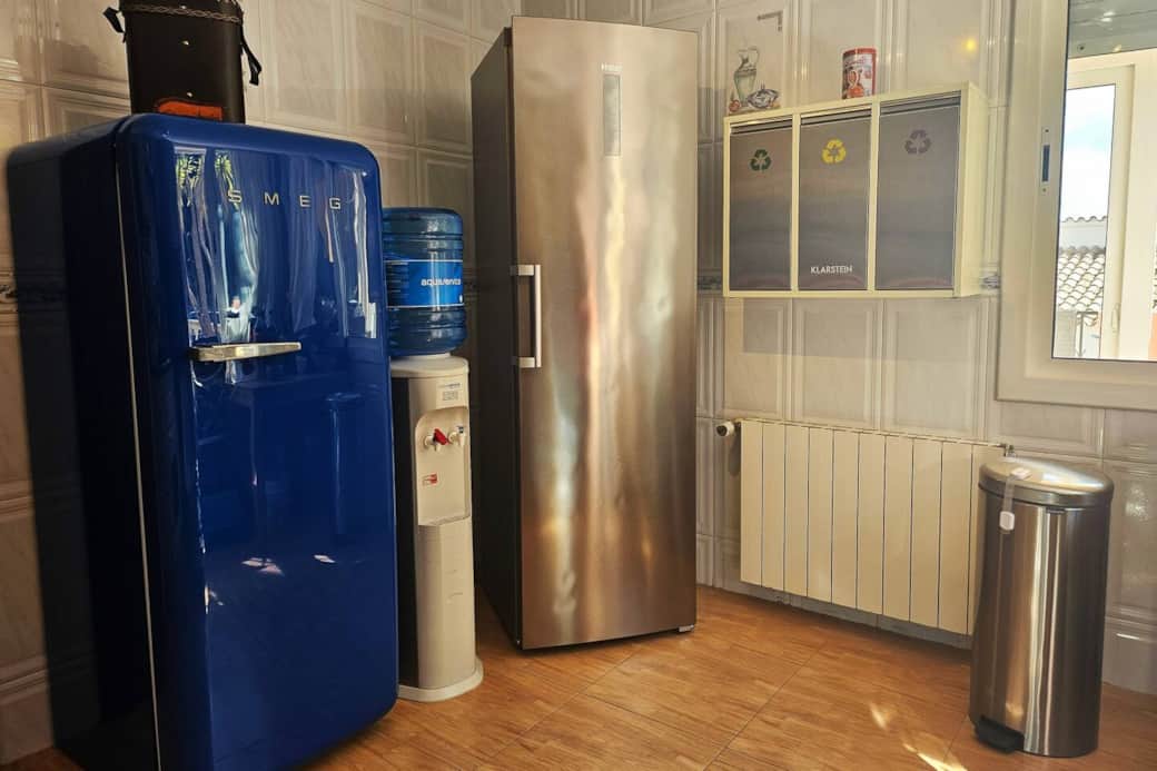 The other side of the kitchen with refrigerator, freezer, water dispenser and the recycling bins.