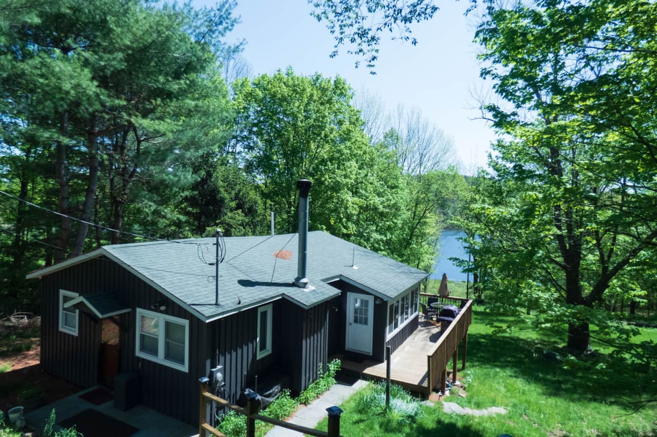 This Lakefront Kenoza Cottage is perched hillside with sweeping views of the lake.