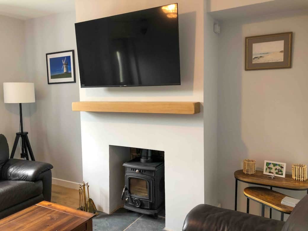 Living room with wood burning stove and 4K TV