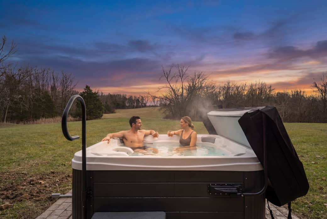 Unwind in the private hot tub at sunset with peaceful countryside views.