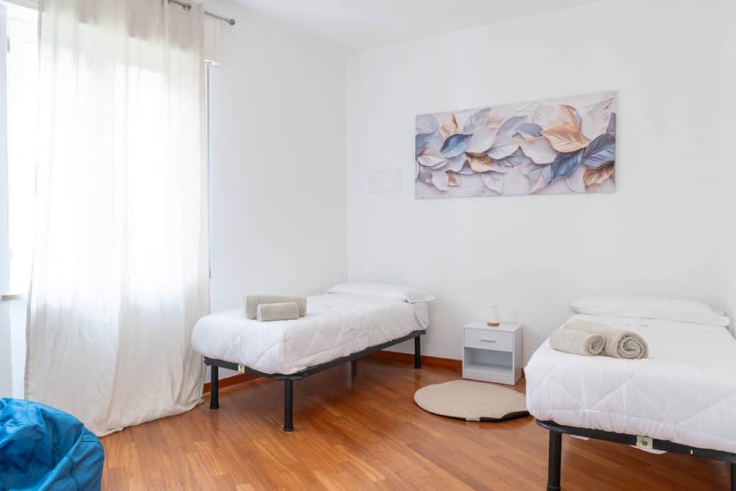 Camera da letto 3 con due letti singoli, molto spaziosa con cassettiera, appendiabiti e pouf.