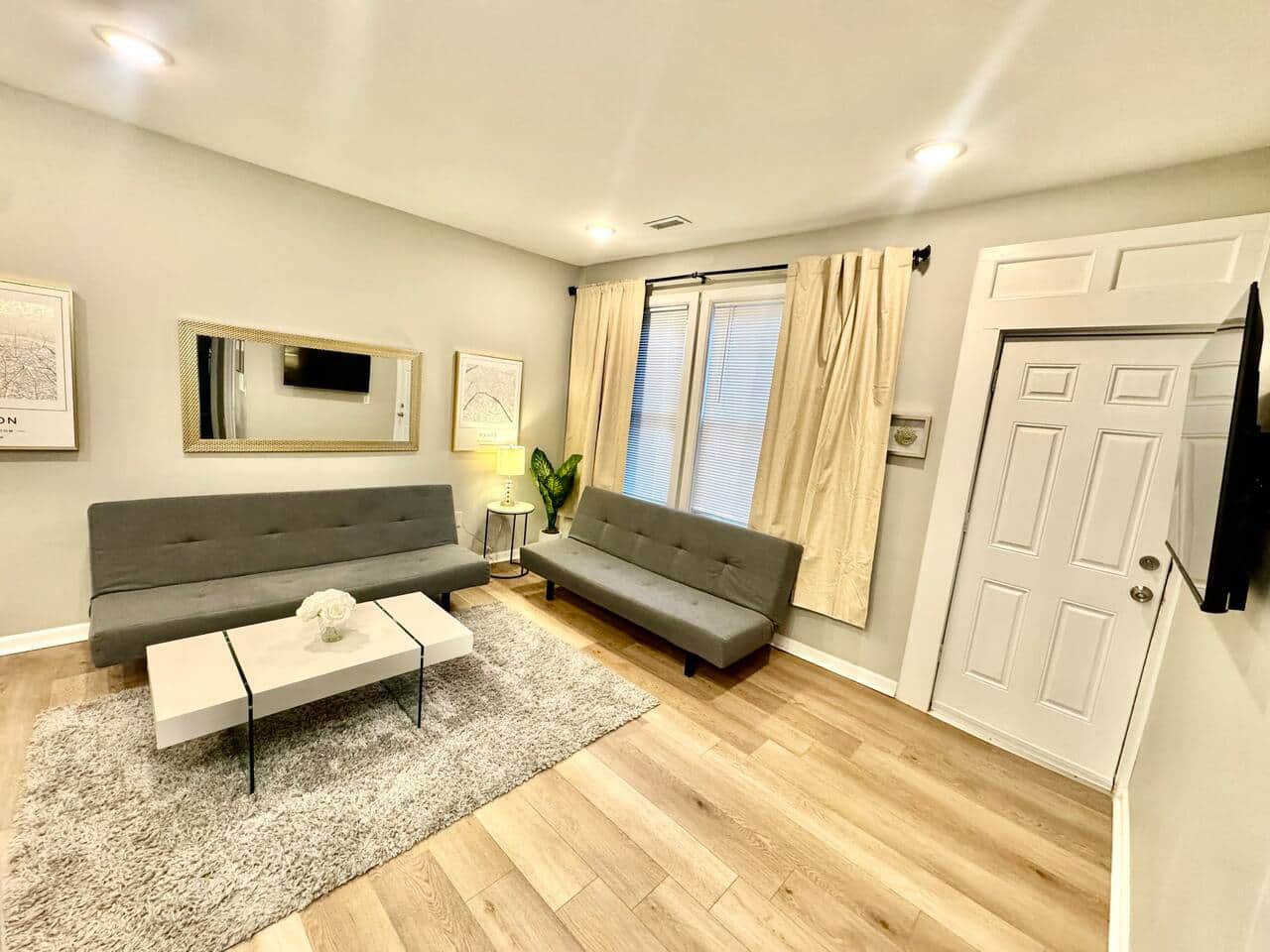 spacious living room! It features 2 futon sofa beds, perfect for accommodating extra guests. Enjoy your favorite shows on the 50-inch TV,  Cozy up by the fireplace underneath for a warm atmosphere. There’s a door that leads to a small balcony outside