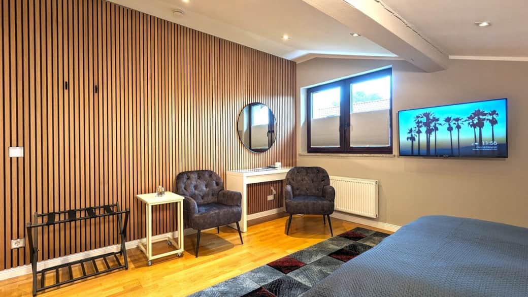 Stilvoller Sitzbereich mit TV, Schreibtisch und moderner Einrichtung im großzügigen Zimmer