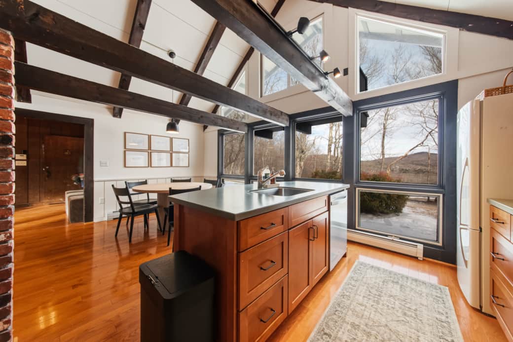 Bright, open kitchen with island seating and wooded views Bright, open kitchen with island seating and wooded views