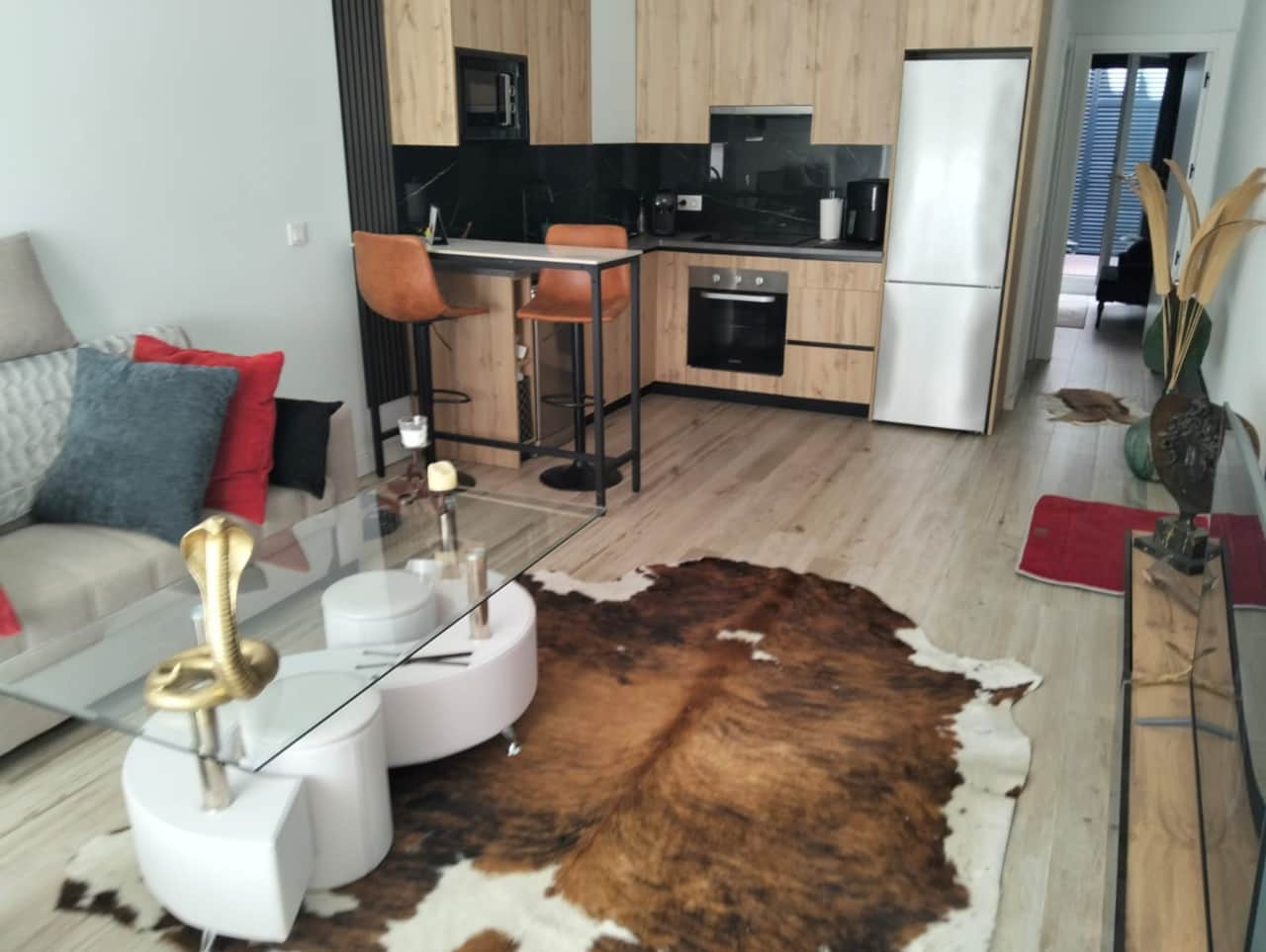 Salón con sofá, mesa de centro y cocina abierta