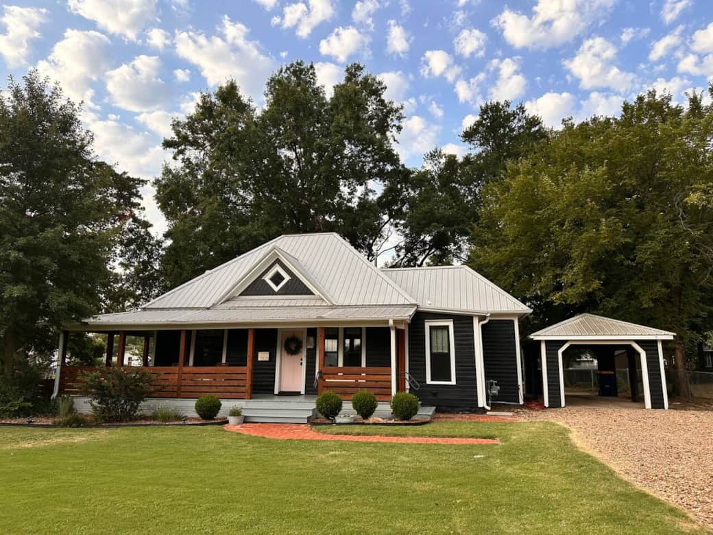 Restored 1922 home featuring a bold black exterior and the iconic pink door of Stillwater.