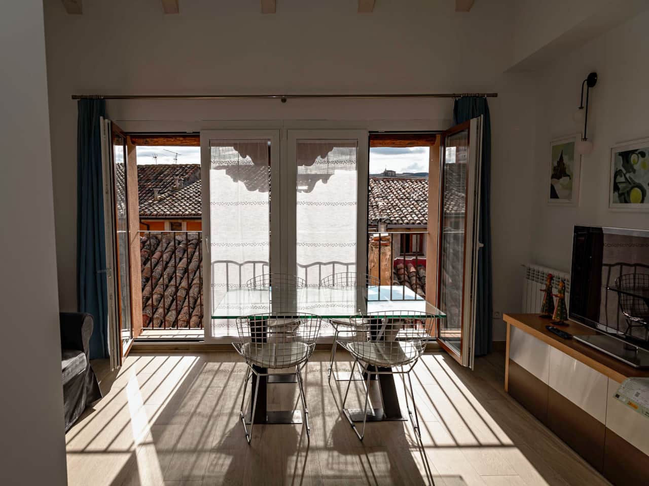 Salón comedor con balcón y vistas a los tejados