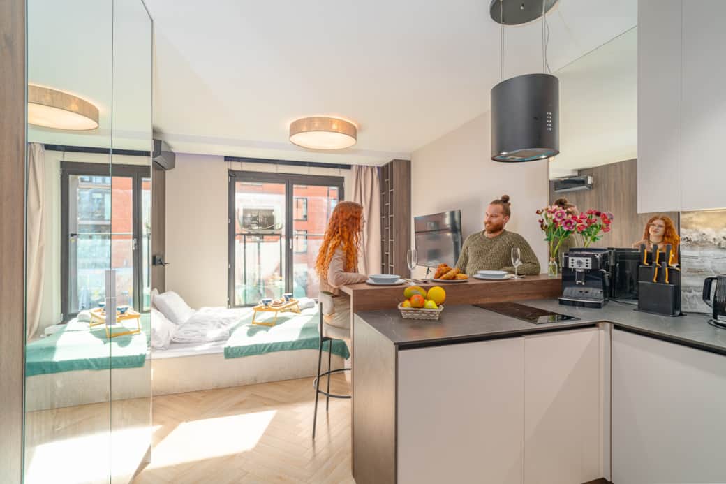 Bedroom zone with large bed, window and wood finishes.