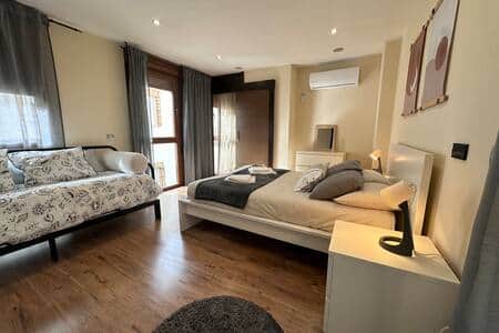 Dormitorio con cama doble, aire acondicionado y sofá cama