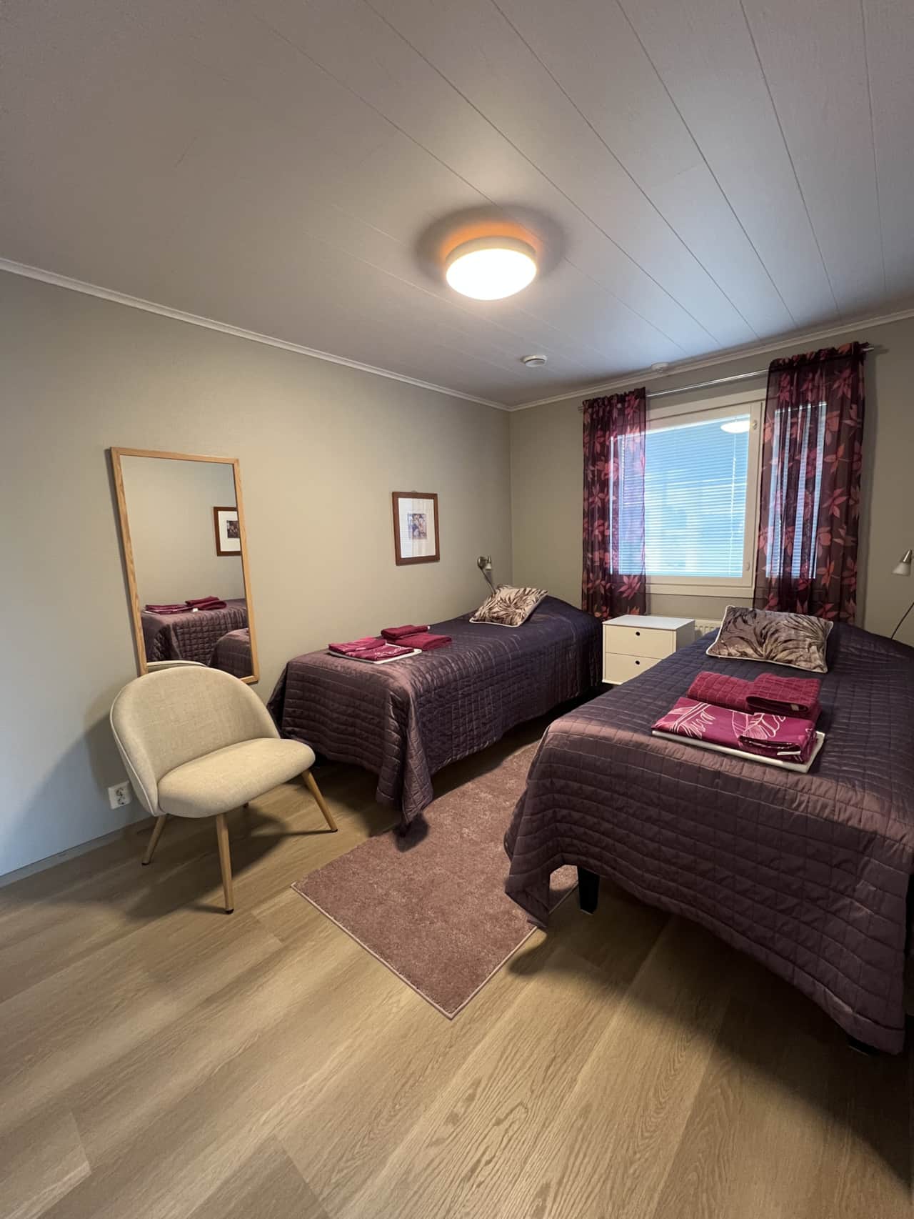 The bedroom has two separate beds a and a wardrobe.
