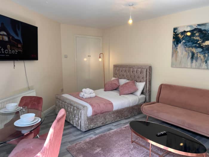 Pink Paradise apartment with a double bed and pink sofa