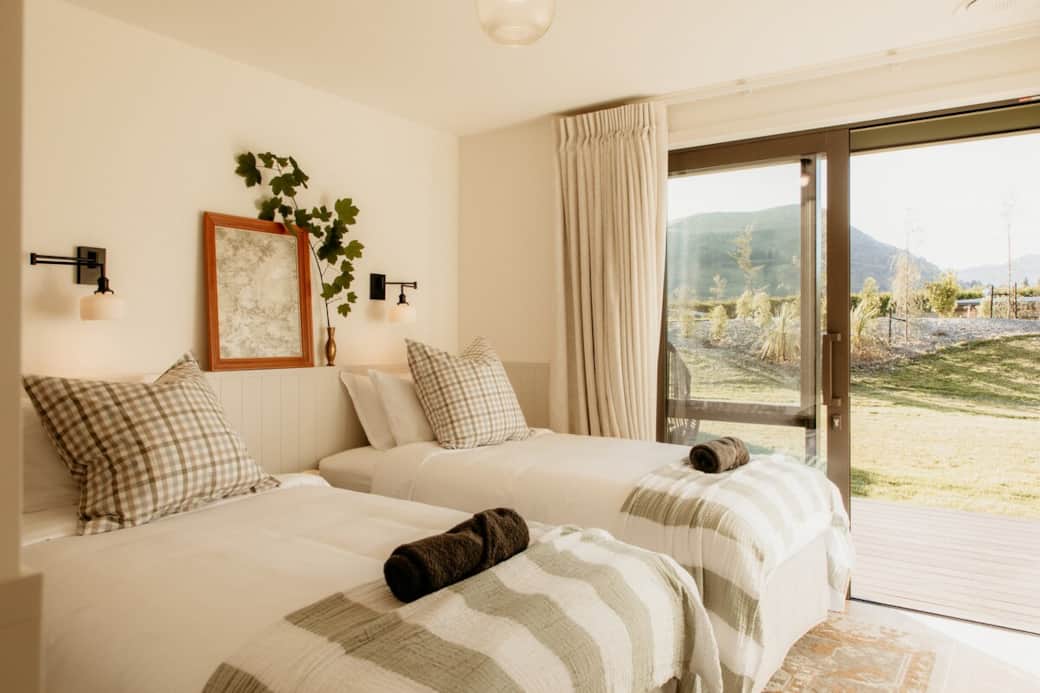 Premium bedding on two "King Single" beds (a NZ size that's wider and longer than a child's single bed) with views of Coronet Peak. Blackout curtains covering lockable stacking sliders that open out to the deck and private garden. 