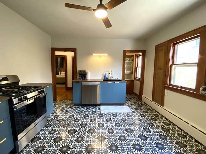 Spacious eat-in kitchen with stylish patterned tile floors, modern appliances.