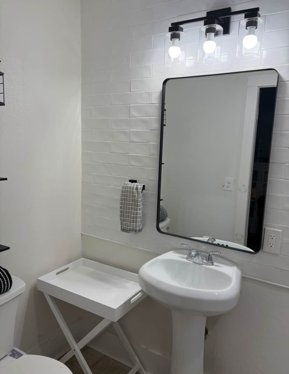 Downstairs bathroom vanity and mirror with modern finishes at White Magnolia Galveston