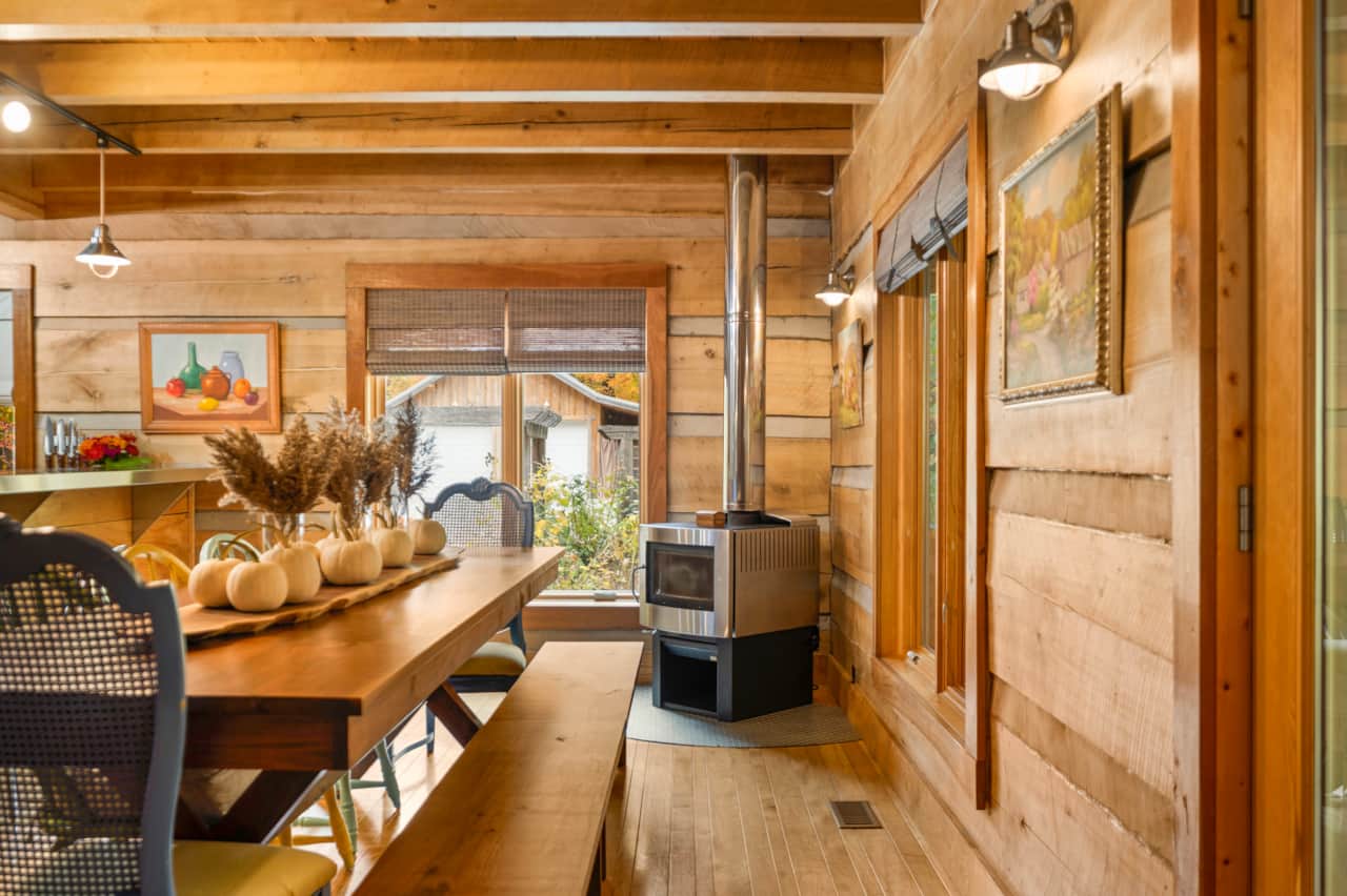 Dine fireside next a wood burning Pacific Energy wood stove.  Custom handcrafted black walnut 9' dining table with 2 benches and chairs for 5.  