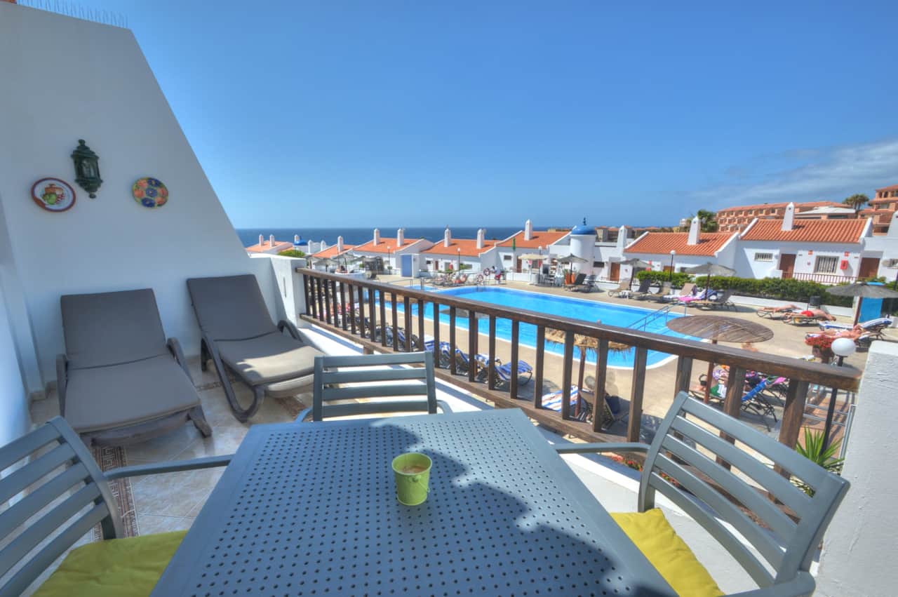 Balcony with pool, resort and ocean views.