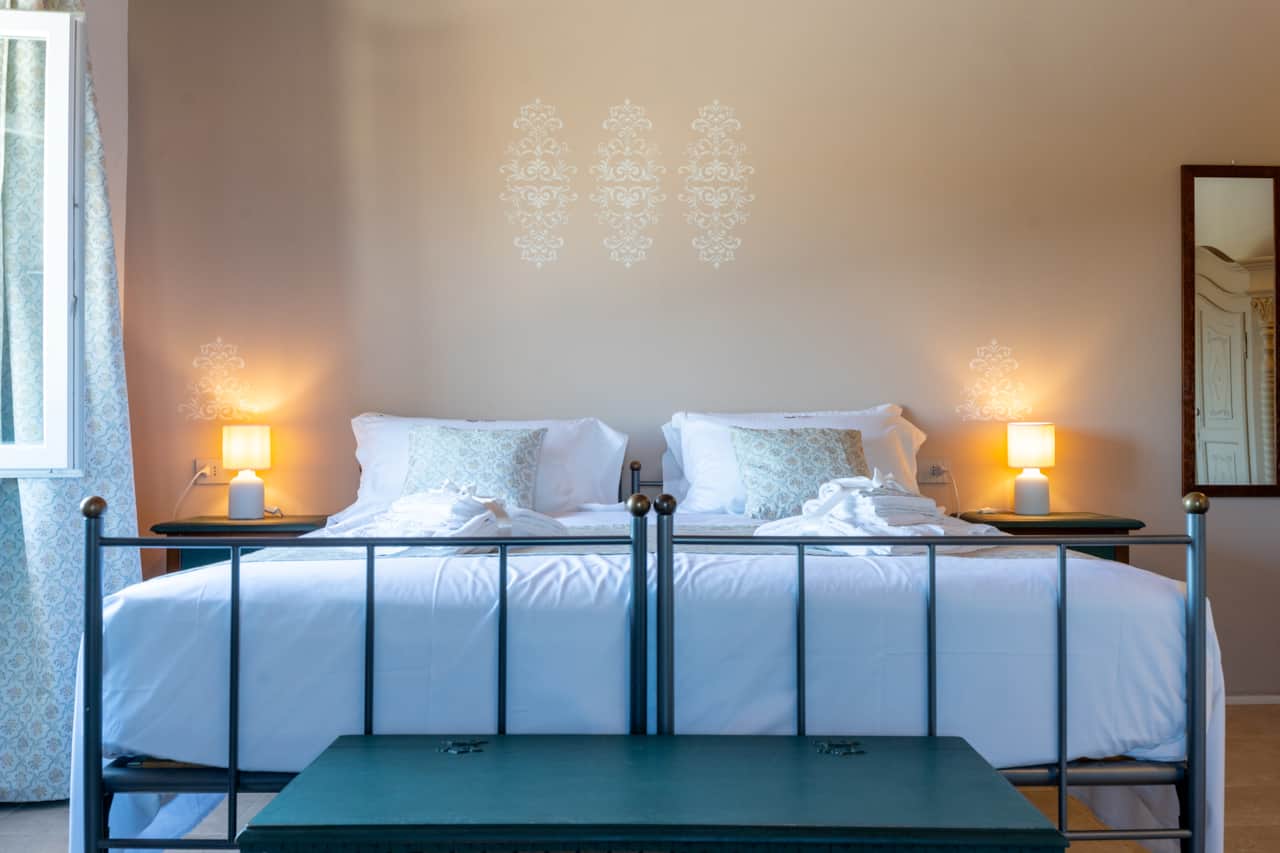 Comfortable king size bed in the room Rosmarino, with feather pillows and quality linen