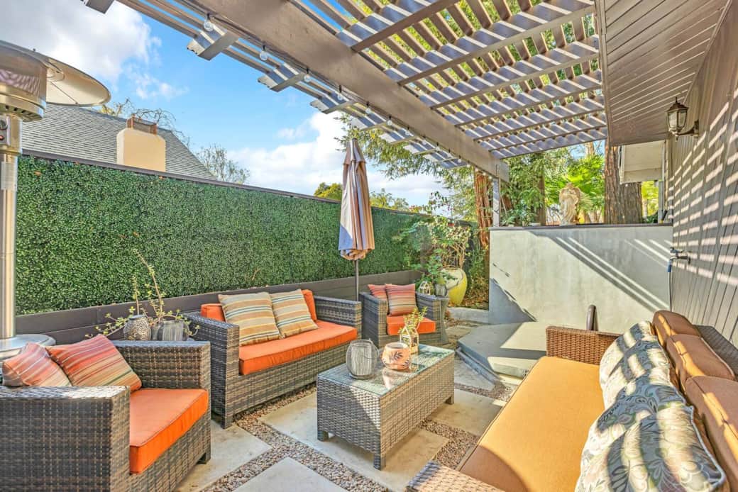 Private patio with pergola and cozy seating for coffee or evening chats.