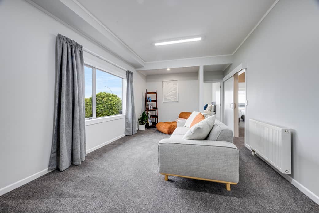 Separate TV lounge with comfy sofa, looking across the reserve to Lake and Mountain views.