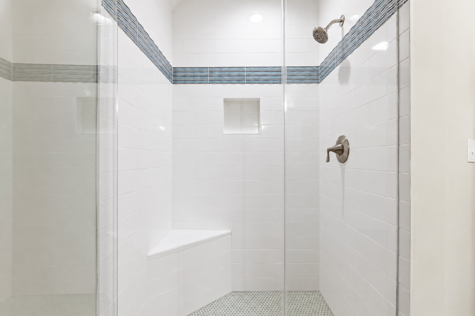 Step into the glass shower with a built-in bench and wall niche for your shower essentials.