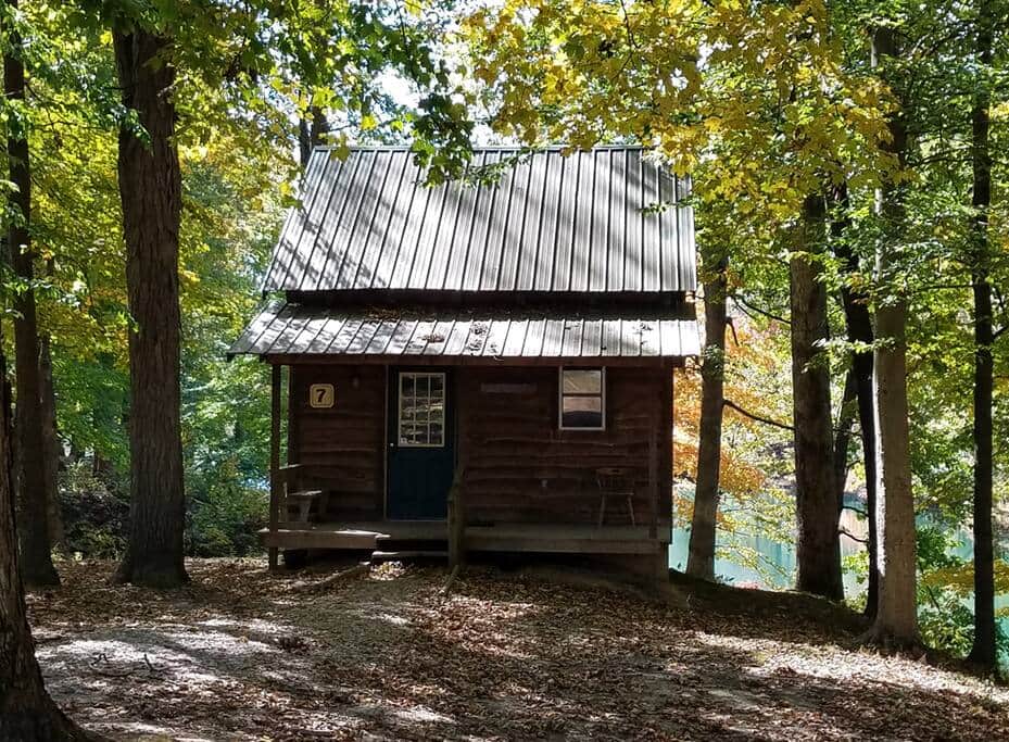 Rustic Cabin7 sits on the edge of Pastor Baggett Lake and next to Hippy Hill Stage.