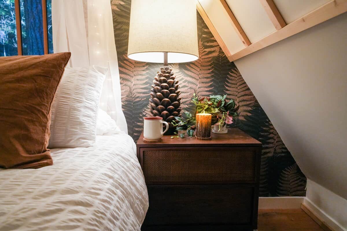 The bedroom features a cozy queen size bed and two large side tables with beautiful pinecone lamps!  