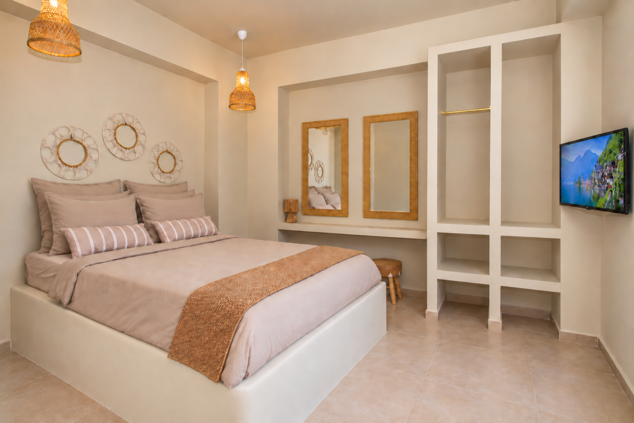 A warm boho bedroom with a TV at Villa Pastida II in Pastida, Rhodes.