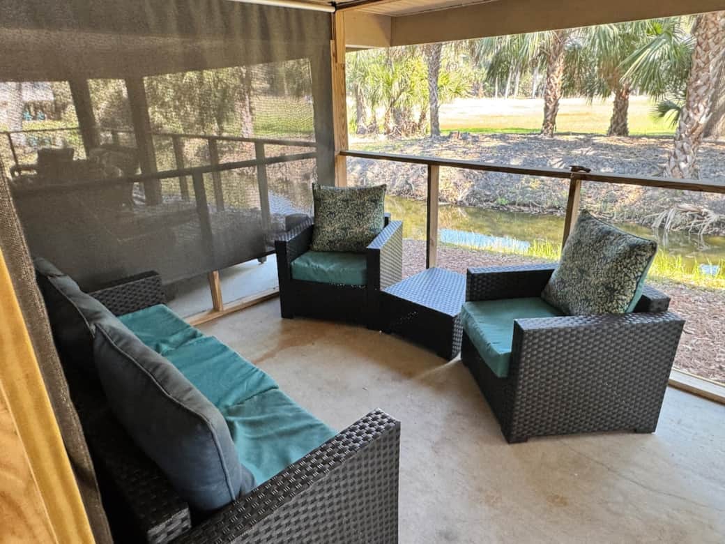 Screened patio overlooking the lagoon, palm trees and golf green