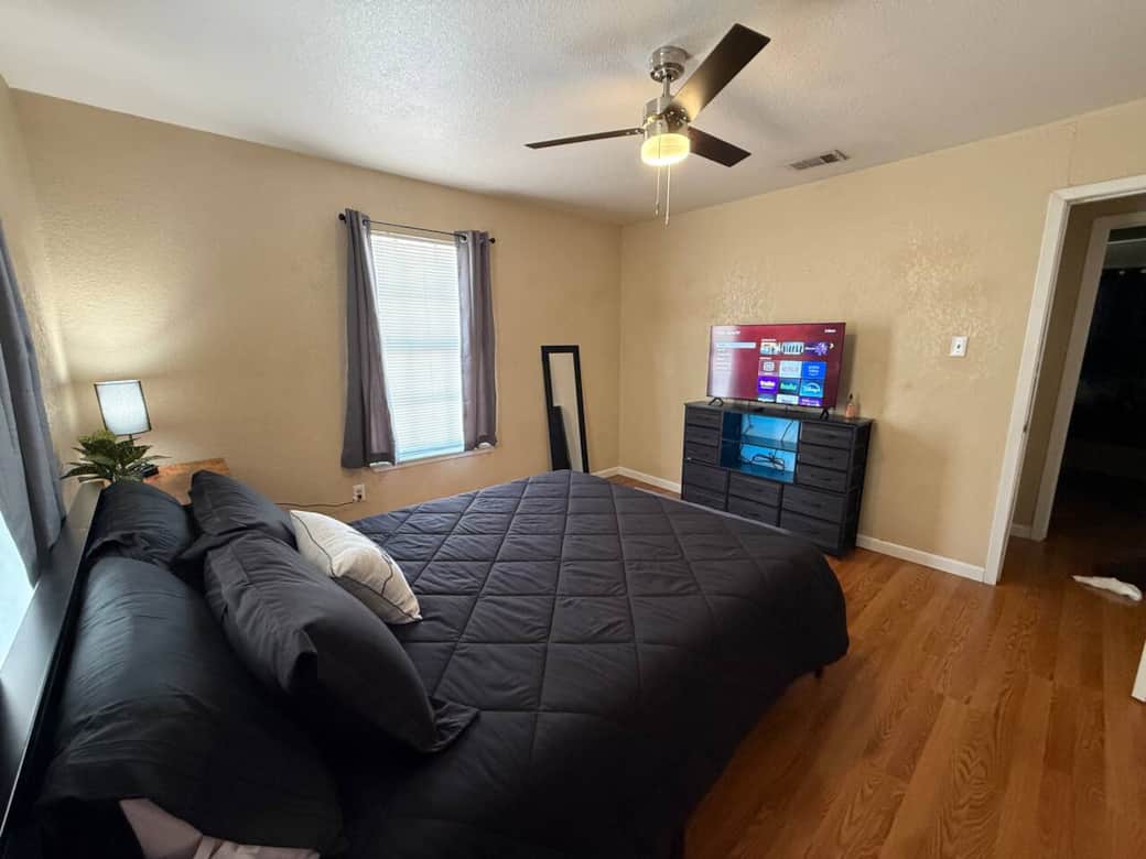 Comfortable queen bed in bedroom with its tv and working space. 