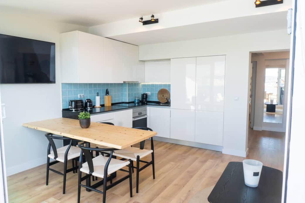 A full view of the bright, modern kitchen and dining area, flowing right into the living space.