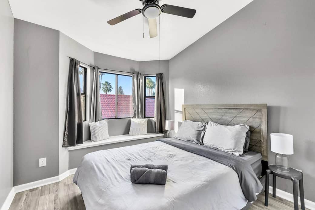 Secondary bedroom with a queen bed, ceiling fan, and a built-in window seating.
