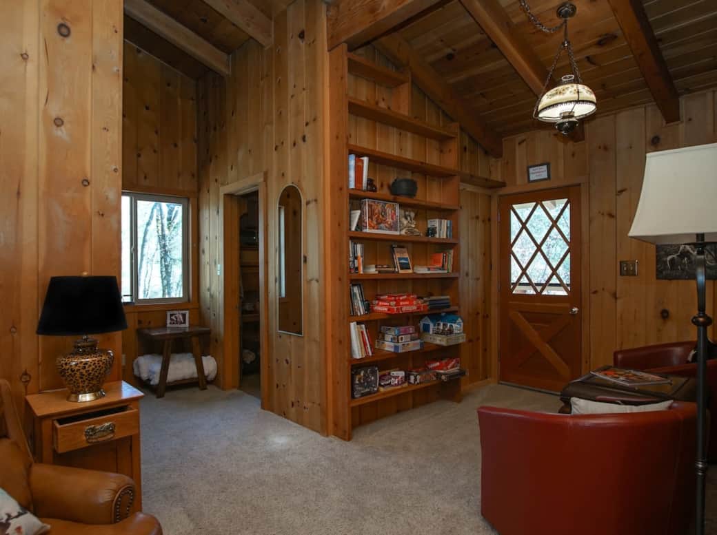 An inviting upper-level retreat stocked with books and board games. This central space connects The Twin Star Loft to the Bridle Room, offering shared access to the beautiful balcony overlooking the property's pines and oaks.